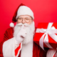 Santa Clause gesturing for you to be quiet.